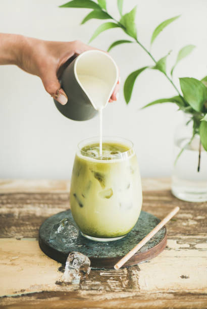 istock Iced matcha latte drink with milk pouring from pitcher 1054925832