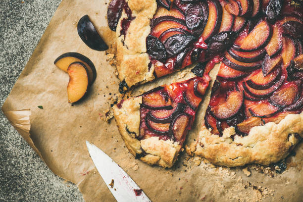 istock Flat-lay of plum galetta sweet cake on baking paper 1054925836