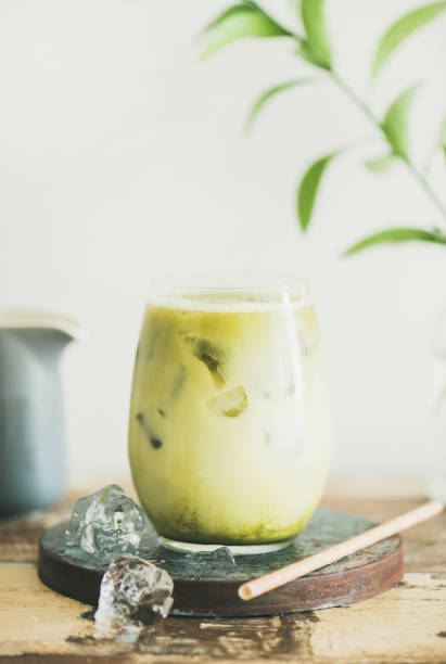 istock Iced matcha latte drink, white wall at background, close-up 1054925840