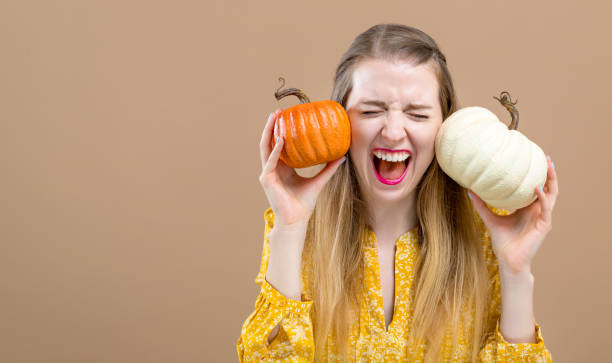 istock Young woman holding pumpkins 1054927582