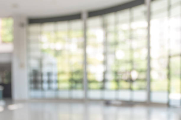 istock Blur background interior view looking out toward to empty office lobby and entrance doors and glass curtain wall 1054929760