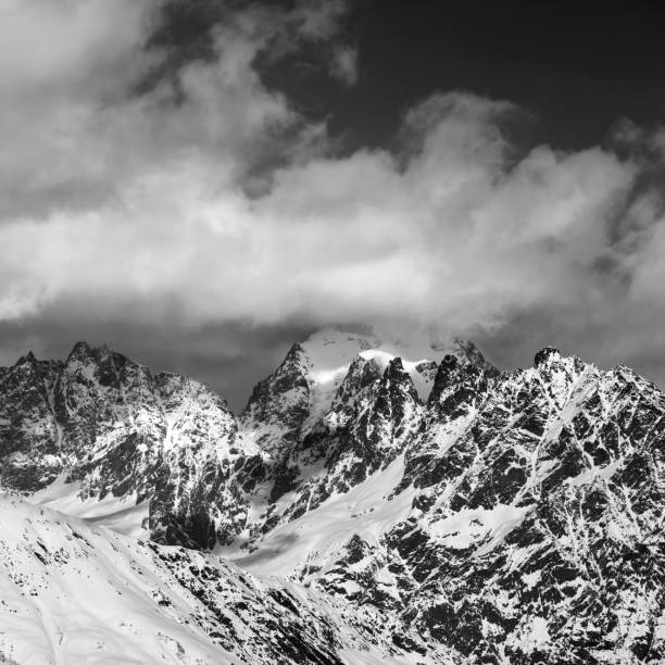 istock Black and white snowy rocks in clouds 1054930328