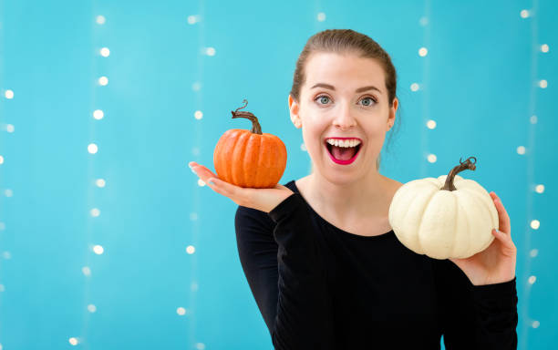 istock Young woman holding pumpkins 1054930550