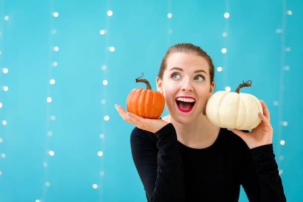 istock Young woman holding pumpkins 1054930554