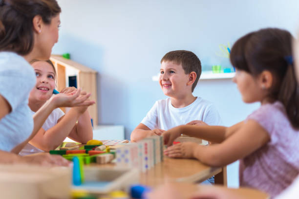 istock Preschool teacher with children playing with didactic toys 1054930918