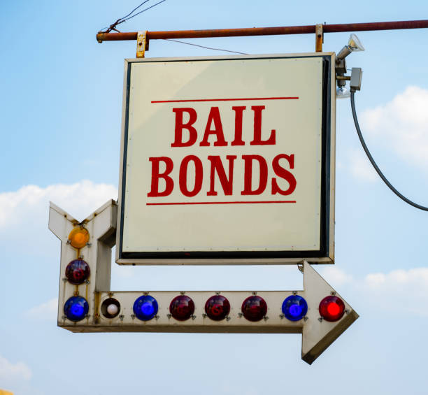 Aging Vintage Sign in Front of Small Town Bail Bonds Office A rusty white bail bonds sign needs bulbs replaced but still points at the office entrance bail stock pictures, royalty-free photos & images