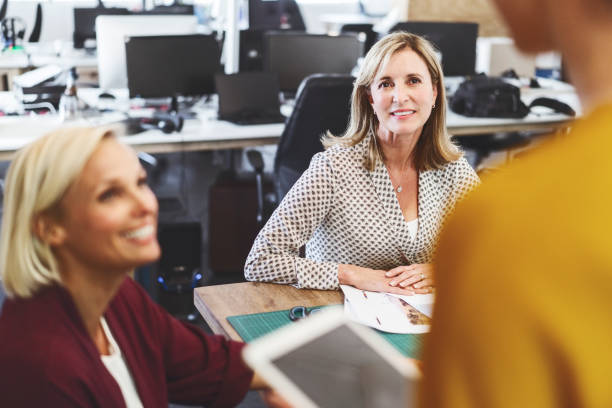 istock Smiling female professionals looking at colleague 1054944044
