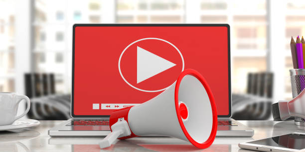 istock Megaphone, bullhorn and Video player on a computer screen. Blurred office background, close up view. 3d illustration 1054945528