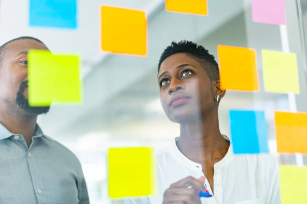 istock Mid adult colleagues looking at adhesive notes 1054947188