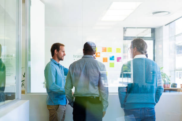 istock Colleagues discussing in office seen through glass 1054948108