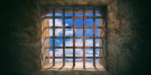 istock Prison, jail rusty window and blue sky view on old wall background. 3d illustration 1054948176