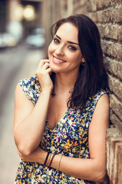 istock Girl with blue eyes smiling on brick wall. 1054948732