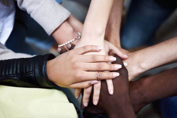 istock Top view of young people putting their hands together. 1054948894