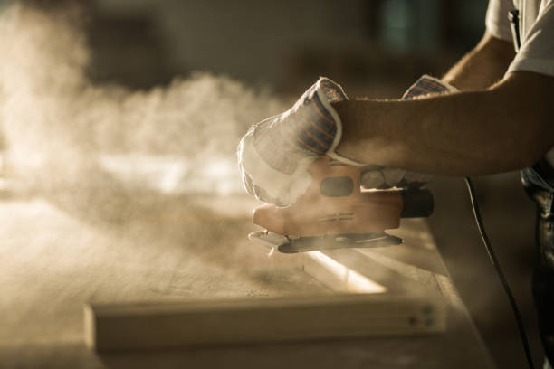 gros mâle ouvrier travaillant avec la ponceuse sur une planche de bois. - work tool carpentry construction wood photos et images de collection