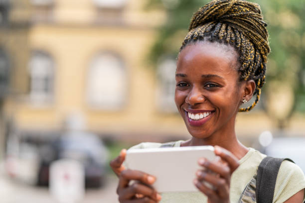istock African woman using smart phone on the street 1054950760