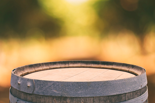 Image of old oak wine barrel in front of bokeh landscape. Useful for product display montage