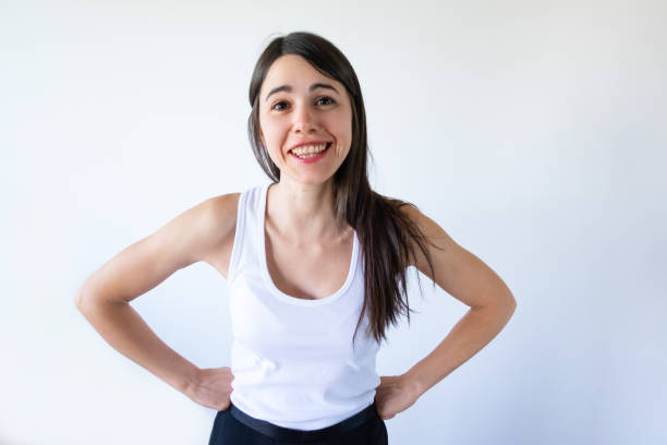 istock Positive brunette girl holding hands on hips and laughing 1054963210