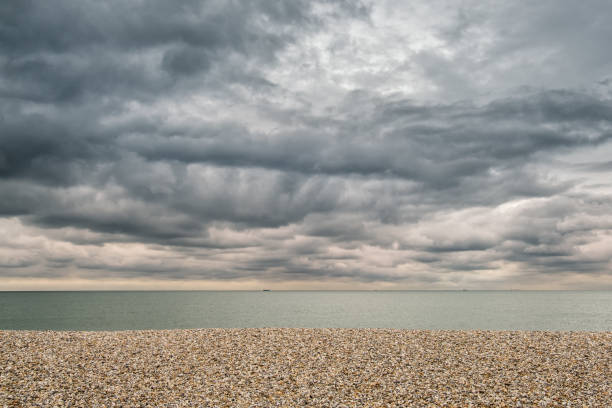 plage de galets et de ciels orageux au cours de manche - witterung photos et images de collection