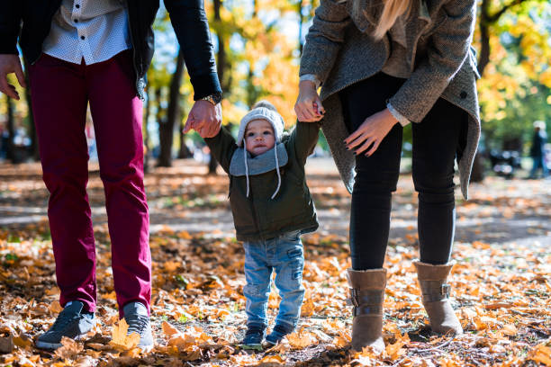 les premiers pas de bébé. une famille heureuse. - baby first steps autumn child photos et images de collection