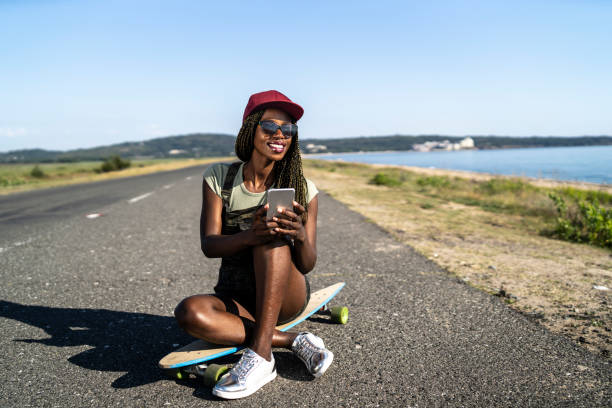 istock Female skater with a hat sitting on board 1054969362