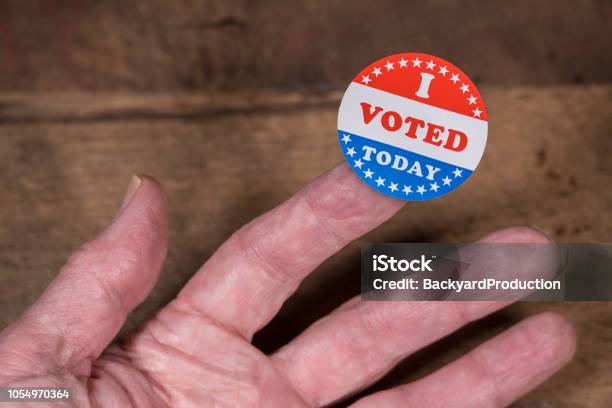 Hoy He Votado En Etiqueta Engomada De Papel En Mans Dedo En Mesa De Madera Rústica Foto de stock y más banco de imágenes de Votar