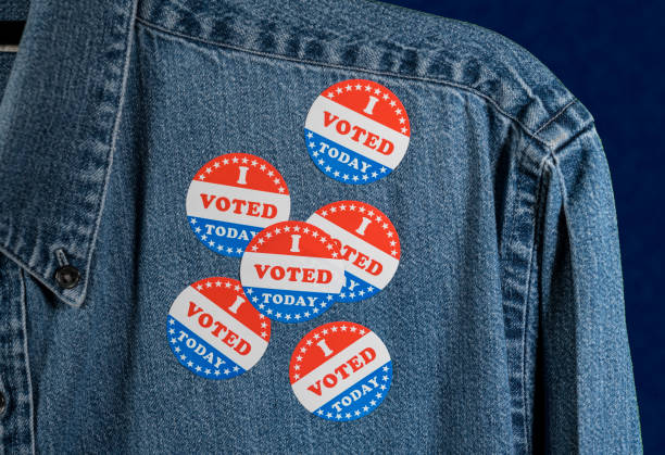 istock Blue denim working clothing with many Voted stickers on dark background 1054970410