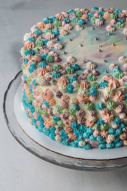 istock Buttercream frosted birthday cake on light background. Copy space. Close up. Vertical. Celebration concept. 1054971152
