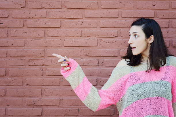 istock Young woman pointing at copy space 1054976416