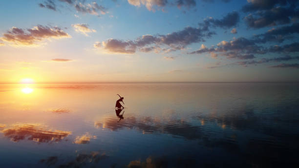 istock Ballerina dancing on the lake at sunset. 1054976718