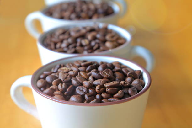 Cups of heap coffee bean on wooden table