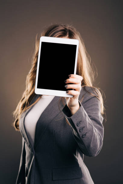 istock Woman holding tablet in front of her face 1054980530