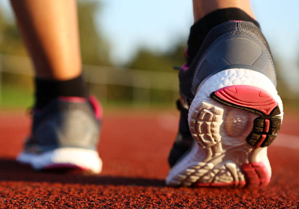 istock Woman running on athletic track 1054980848