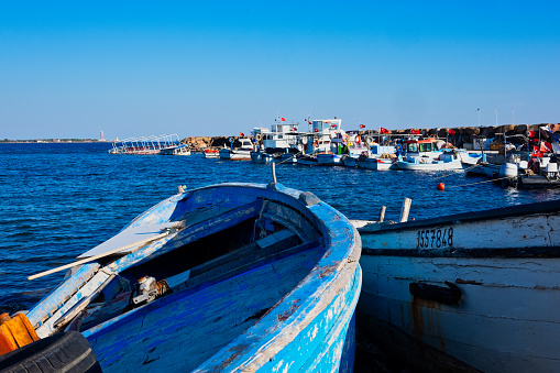 Sokakagzi, Çanakkale / Turkey - October 08, 2018: Close-up view of a blue fishing boat with at the harbor. Docked fishing boats at the back.