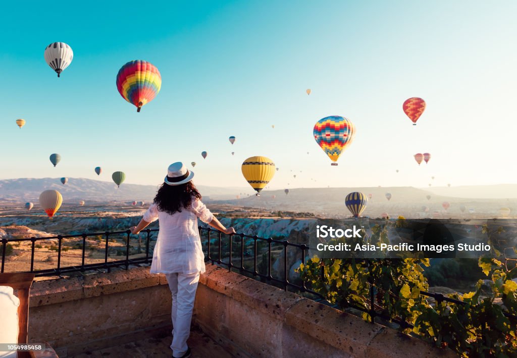 아름 다운 아시아 여자는 화려한 뜨거운 공기 풍선 카파도키아, 산의 Turkey.Turkey 카파도키아 동화 풍경에서 계곡을 날아 보고. 터키 카파도키아 산의 동화 같은 풍경입니다. - 로열티 프리 열기구 스톡 사진
