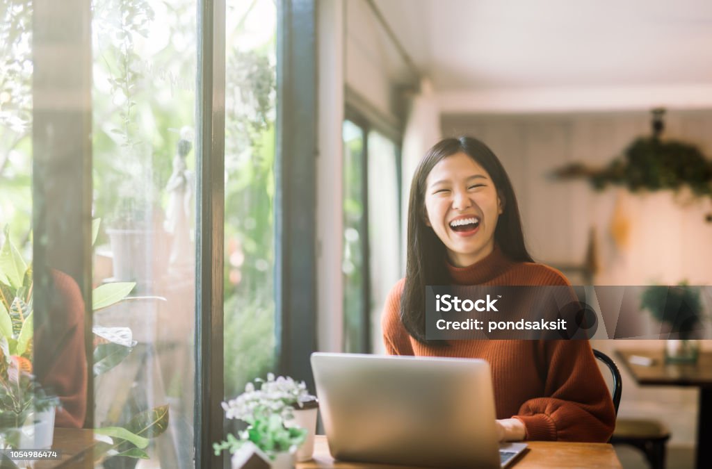 young Asian girl working at a coffee shop with a laptop Happy young asian girl working at a coffee shop with a laptop Asia Stock Photo