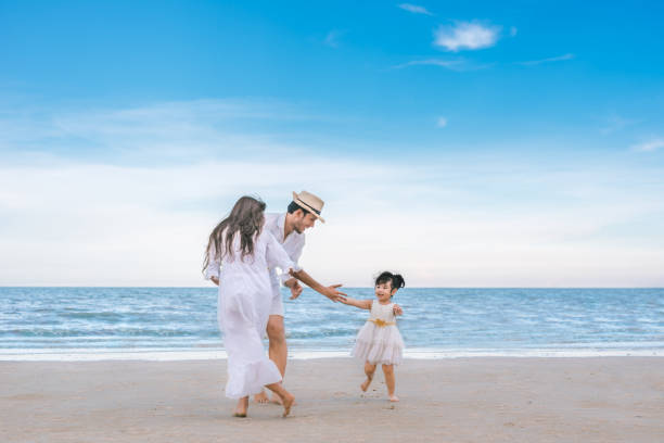 istock Girl playing with family on the beach. 1054987876
