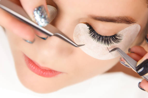 istock Eyelash Extension Procedure. Woman Eye with Long Eyelashes. Close up, selective focus. 1054989732