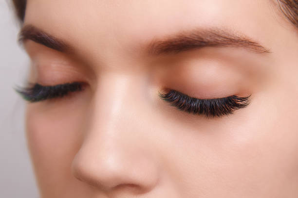 istock Eyelash Extension Procedure. Woman Eye with Long Eyelashes. Close up, selective focus. 1054989752