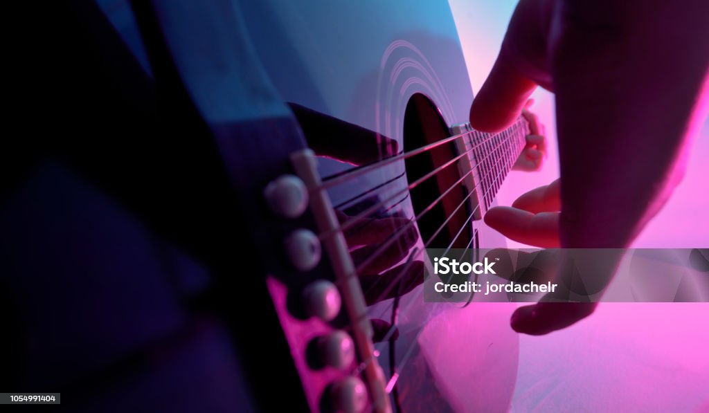 Acoustic guitar played by a girl and colorful lights Acoustic Guitar Stock Photo