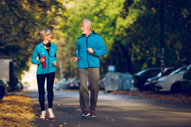 istock Senior couple walking together with water bottles 1054991810