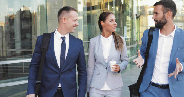 istock Three business colleagues having discussion while walking outdoors 1054992266