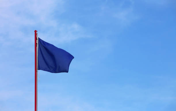 istock blue flag waves on the blue sky with few clouds 1054994196