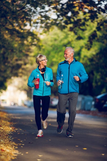 istock Senior couple walking together with water bottles 1054994712