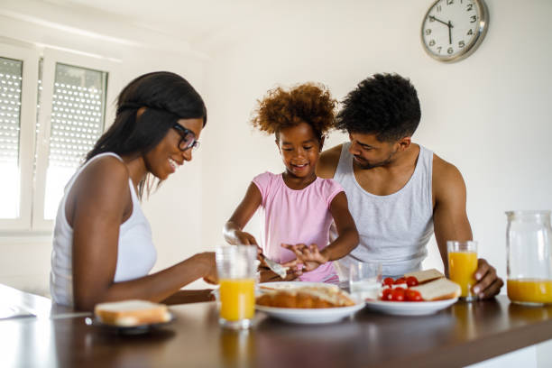 istock Young happy family having breakfast at home 1054996582