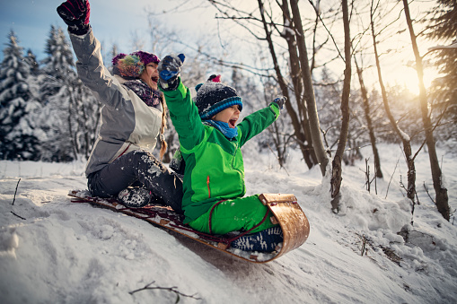 Little boy and his elder sister are sledding with toboggan down little hill. Kids are 12 and 8 years old.  They are enjoying snow, sun and beauty of winter.
Shot with Nikon D850