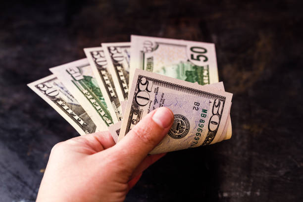 istock Hand Holding Fifty US Dollar Bills Notes 1054999002