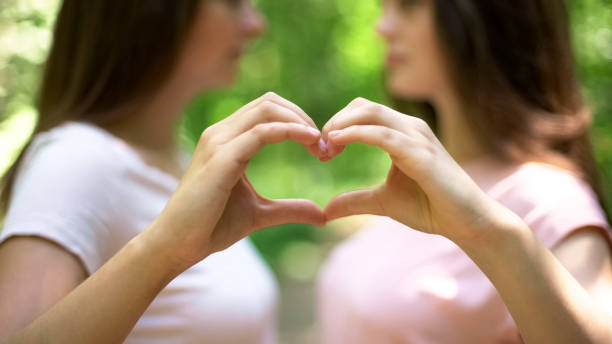istock Two lesbians making heart with hands, free expression of love, lgbt rights 1055004908