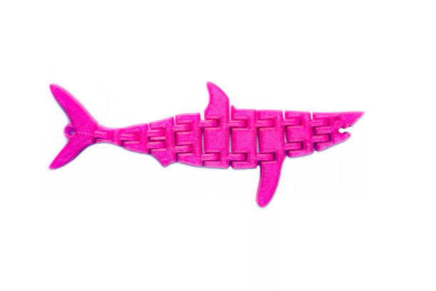 istock Bright light pink object in shape of fish toy printed on 3d printer 1055005622