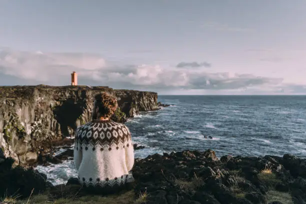 Photo of Man looking at scenic view of lighthouse in Iceland
