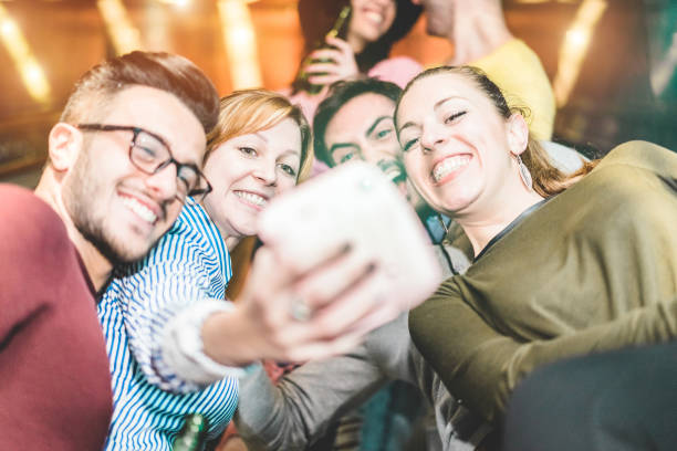 group of friends taking selfie in underground metropolitan station escalator - young people using instant camera at party night  - friendship and technology trends concept - focus on left girl face - happy kid flash imagens e fotografias de stock